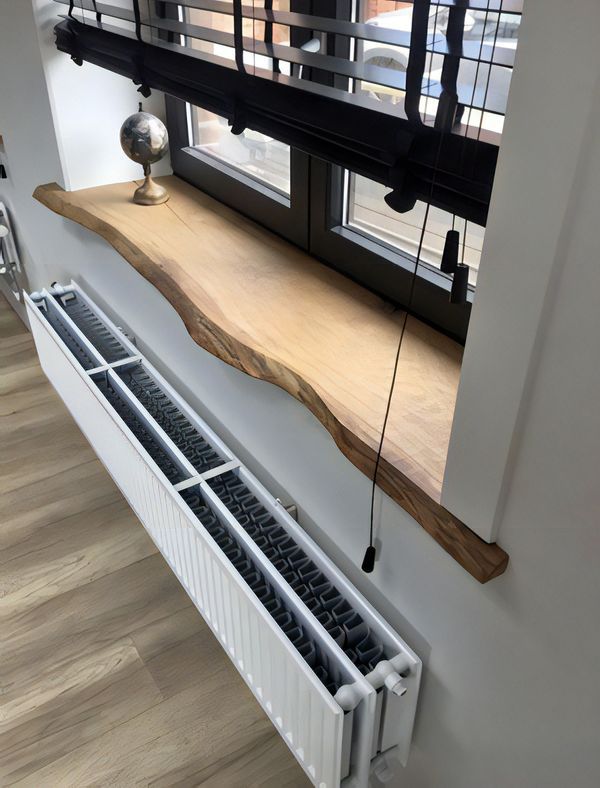 a radiator in the corner of a room with windows and wooden flooring