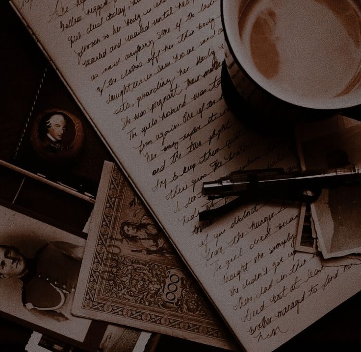 a coffee cup and pen sitting on top of an old paper with writing in it