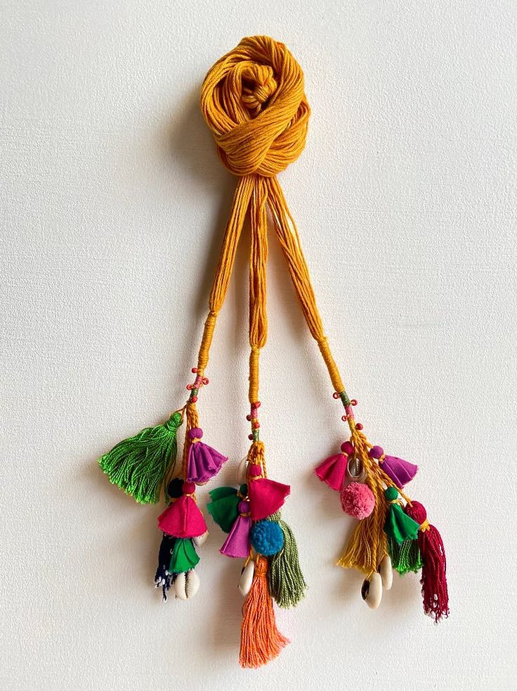 three tassels hanging from a rope on a white wall