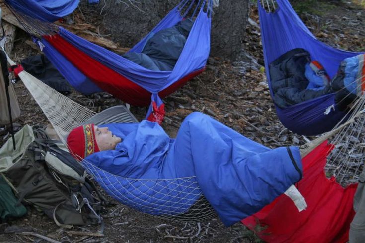 a man laying in a hammock on the ground