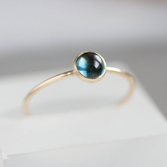 Tiny skinny stackable ring with beautiful London Blue Topaz is a gentle piece for a minimalist style lover. It is made with a skinny but sturdy band, perfect for everyday wear. It is a great addition to a festive outfit too.The ring is 0,8-0,9 mm thick and looks very dainty on the finger. Choose the size of the stone (3 or 5 mm) and material for the ring (sterling silver or 9k gold).If you want to change the ring band design or get a custom ring or ring sets, feel free to contact me.You can orde Sapphire Stackable Birthstone Ring In 14k Gold, Minimalist Blue Sapphire Ring In 14k Gold, Dainty Blue 14k Gold Rings, Blue Stackable Midi Rings, Minimalist Blue Stackable Rings In 14k Gold, Minimalist Blue 14k Gold Stackable Rings, Blue 14k Gold Stackable Rings As Gift, Yellow Gold Topaz Birthstone Ring In Minimalist Style, Minimalist Yellow Gold Topaz Birthstone Ring