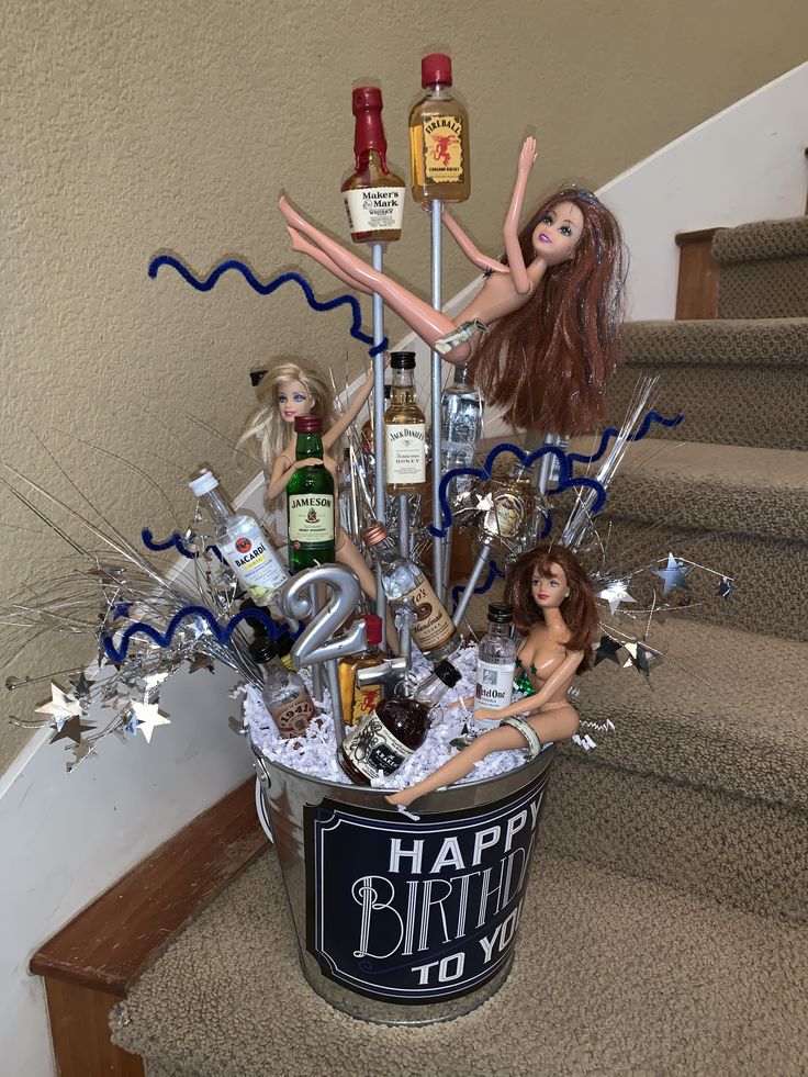 a birthday cake made to look like barbie dolls in a bucket with bottles and confetti