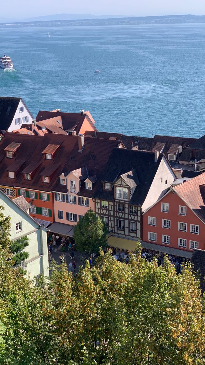 an aerial view of some buildings and the ocean in the background with boats on the water