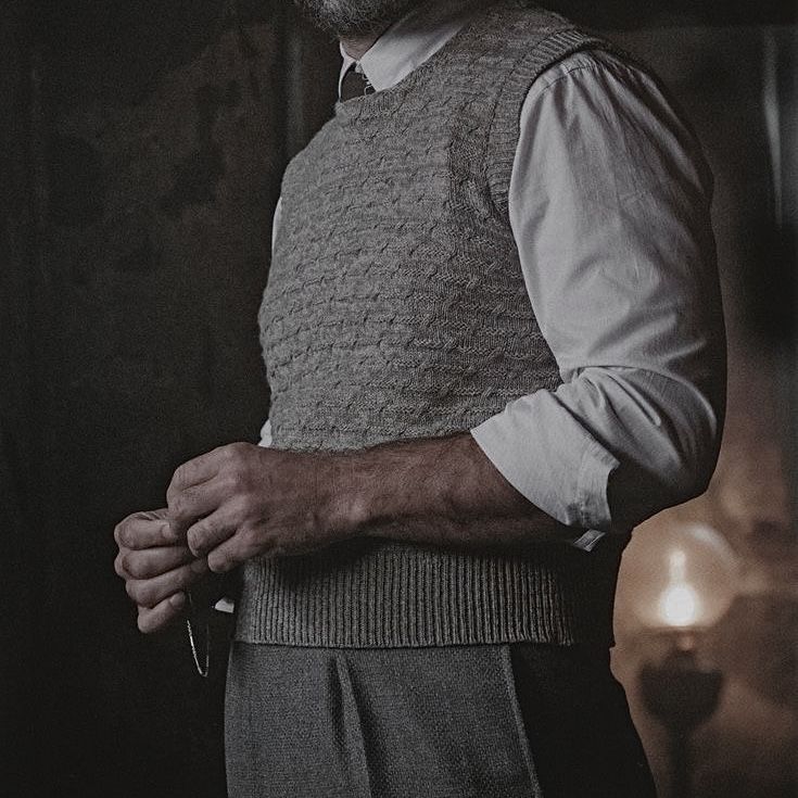 a man with a beard wearing a sweater vest