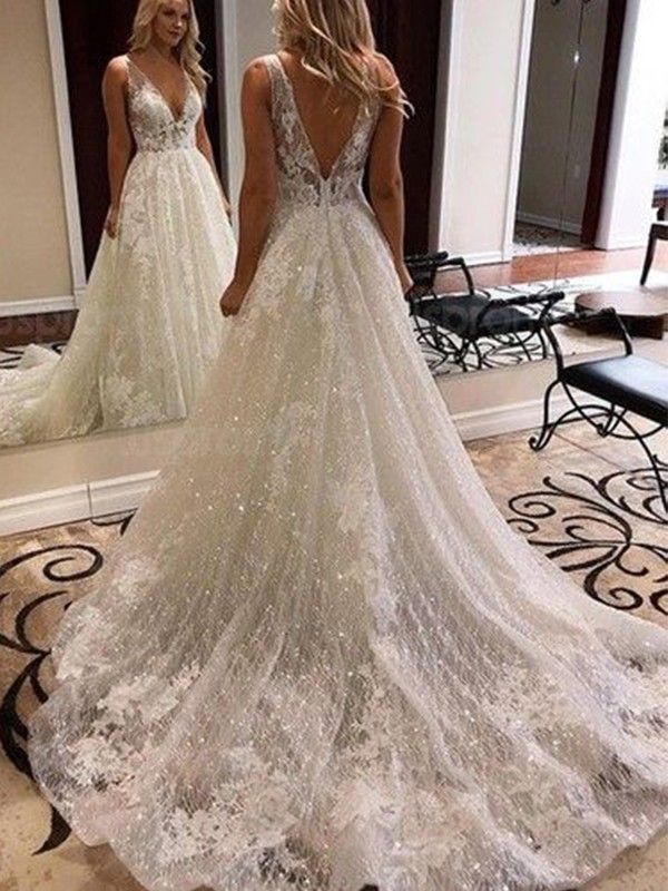 a woman standing in front of a mirror wearing a wedding dress with sequins