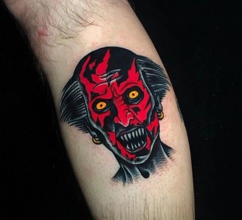 a man's arm with a tattoo on it that has an evil demon face