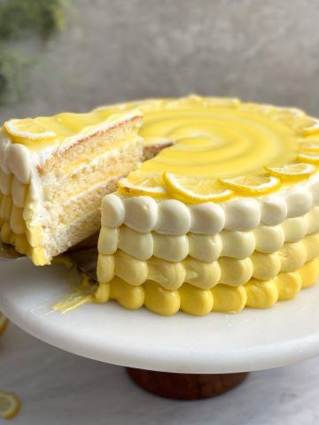 a yellow cake with white frosting and lemon slices