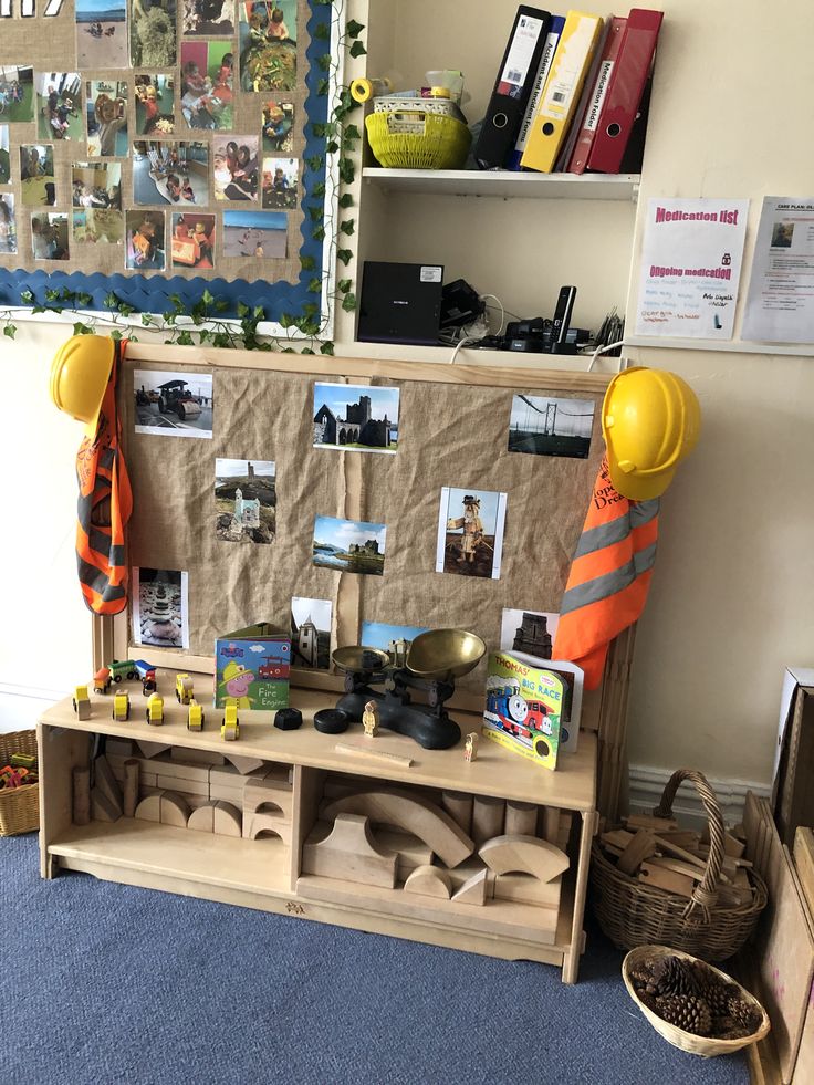 a table with construction themed items on it in front of a bulletin board and bookshelf