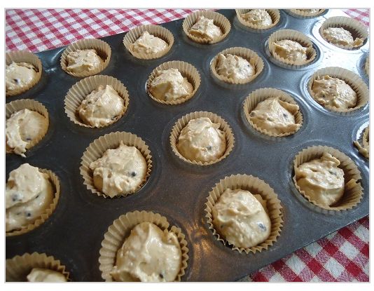 a muffin tin filled with cupcakes sitting on top of a red and white checkered table cloth