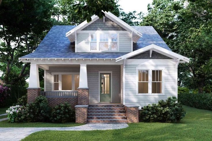 the small house is painted gray and has white trim on the front porch, and two windows