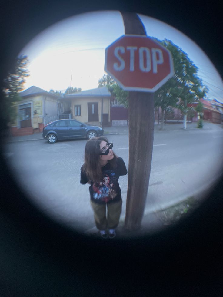 a woman standing next to a stop sign