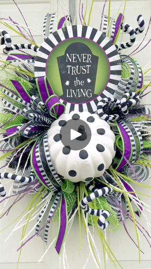 a wreath that says never trust the living with a black and white polka dot on it