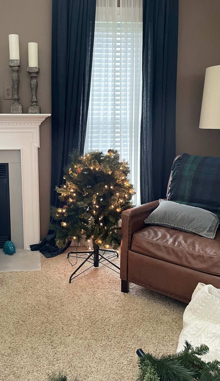 a living room decorated for christmas with a small tree in the corner and lights on