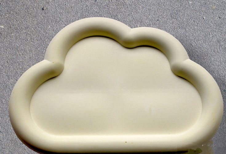 a white cloud shaped object sitting on the ground