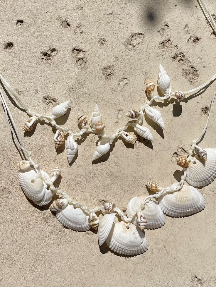 Discover the perfect blend of beachy elegance and boho charm with our Statement Seashell Choker Necklace. Handcrafted from natural white seashells, this unique piece is made for free spirits and beach lovers who want to carry a bit of the ocean with them wherever they go. 🌊 Whether you're dressing for a beach vacation, a seaside wedding, or simply adding a coastal touch to your everyday style, this natural seashell choker is designed to complement any look. Its minimalist, boho style makes it a Ocean-inspired Abalone Shell For Beach, Unique Abalone Shell Necklace For Beach, Handmade Ocean-inspired Shell Necklace, Ocean-inspired Abalone Shell Decor, Adjustable Ocean-inspired Shell For Beach Season, Adjustable Coastal Style Shell Strand, Abalone Shell Necklace For Beach, Unique Shell Necklace For Beach, Abalone Shell-shaped Necklace For Beach