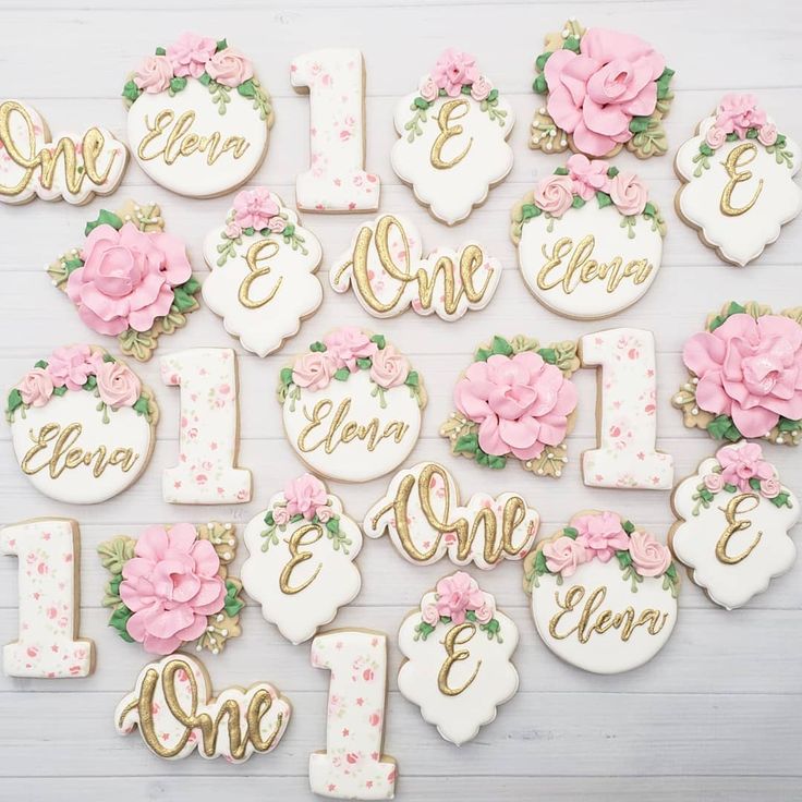 decorated cookies are arranged in the shape of letters and numbers with pink flowers on them