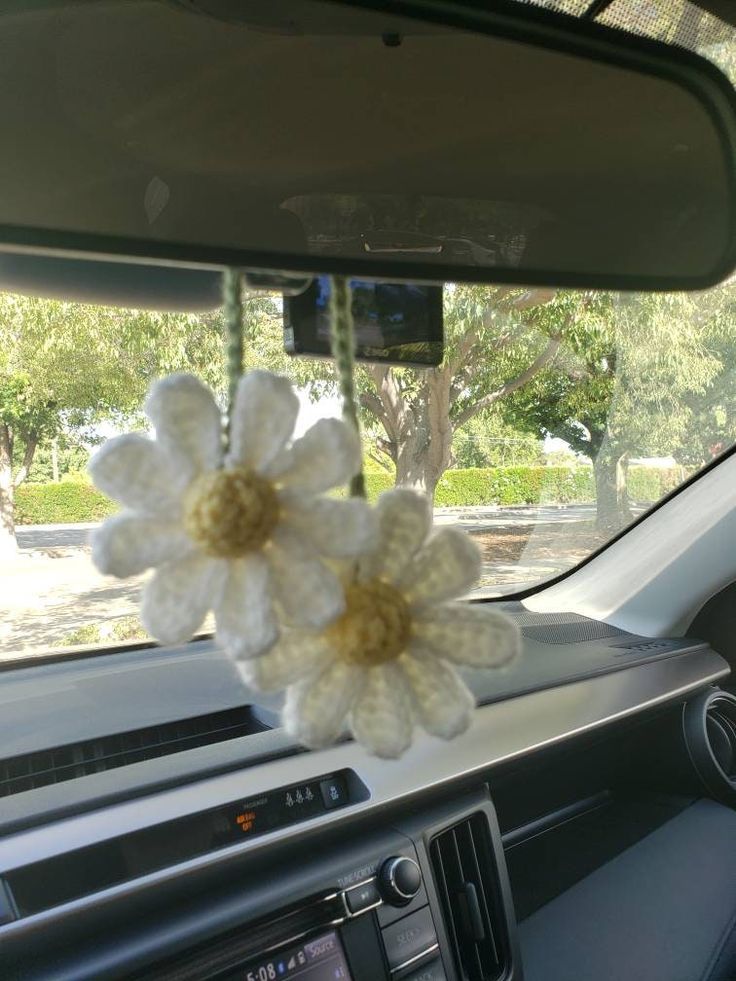 a white crocheted flower on the dashboard of a car