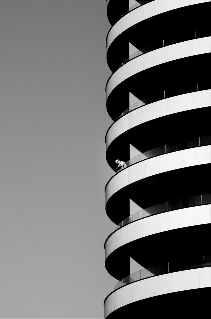 a black and white photo of a building with a bird perched on the top of it