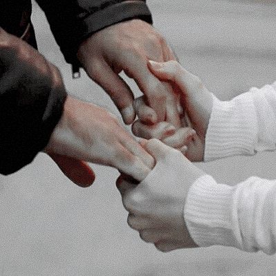 several people are holding hands together in the middle of a circle with their fingers on top of each other