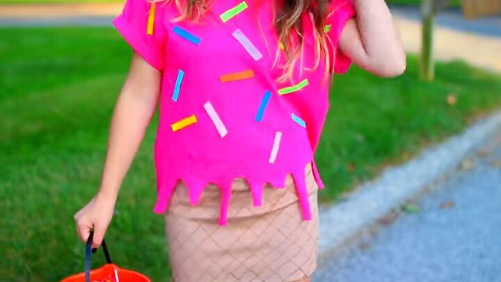 a woman in pink shirt and skirt holding an orange bucket with sprinkles on it