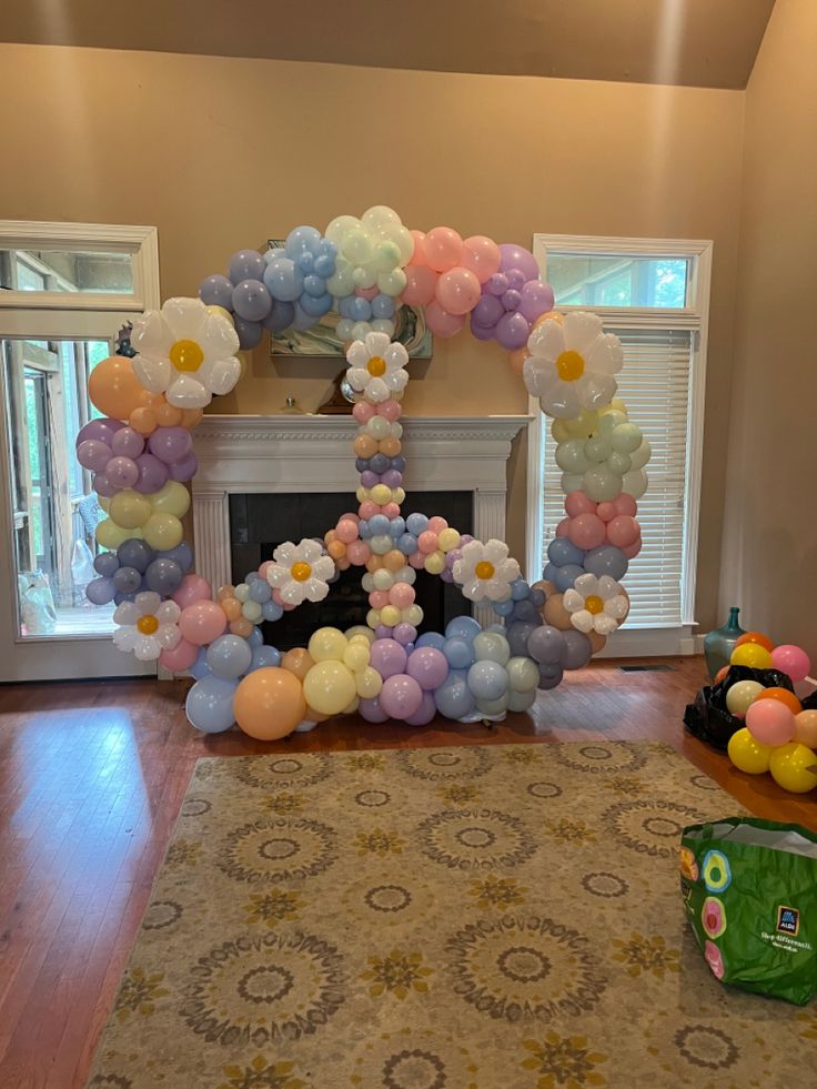 balloons are arranged in the shape of an oork and flowers on a fireplace mantel