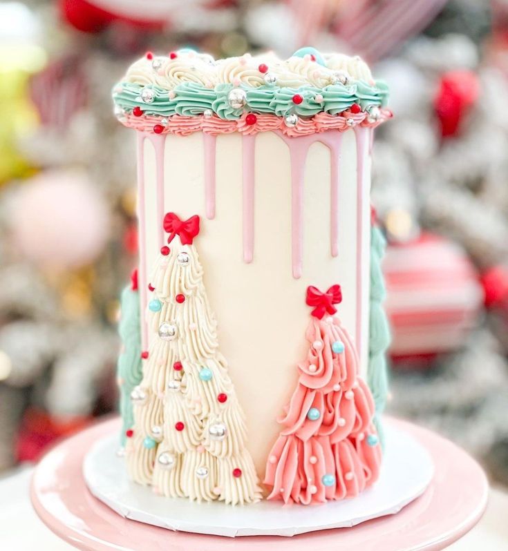 a cake decorated with pink, blue and white icing on top of a table