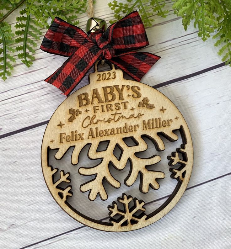 a baby's first christmas ornament hanging from a tree