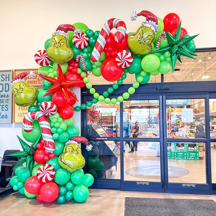 the balloon arch is decorated with grin's and candy canes for christmas decorations