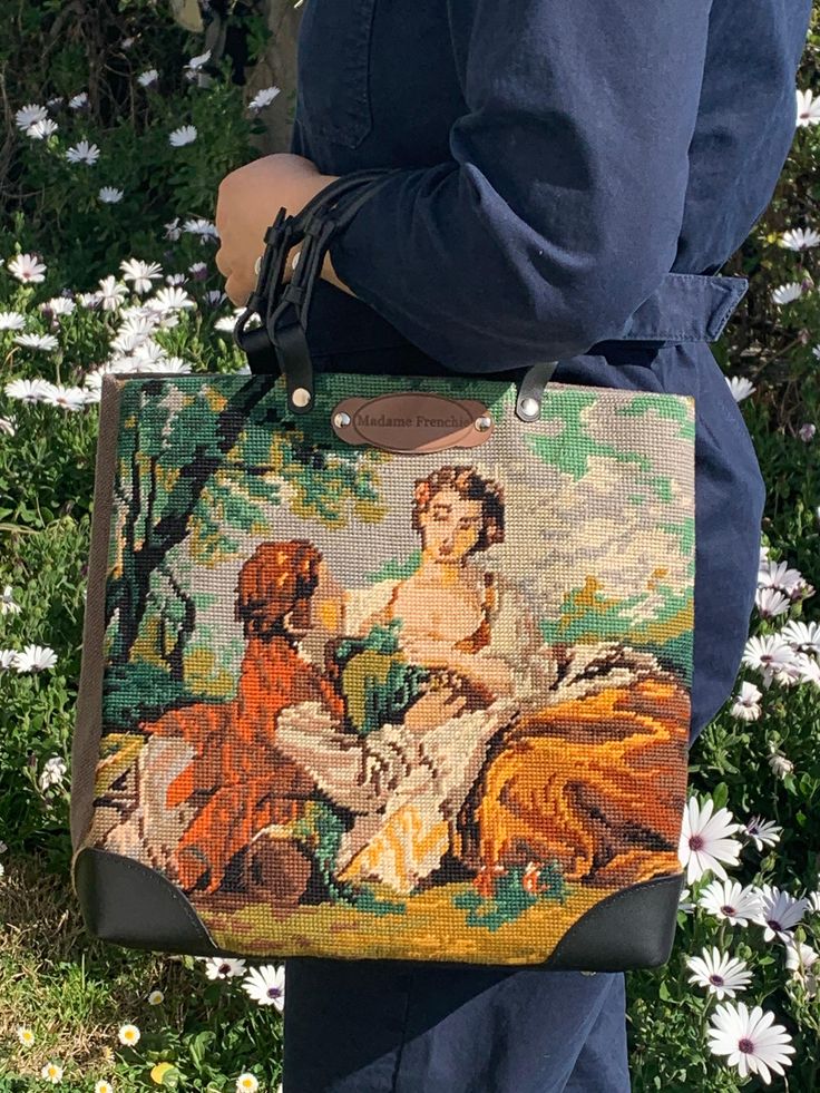 Bag made from a tapestry taken from a canvas by François Boucher, French painter of the 18th century, representative of the Rococo style. The other side of the bag is made of taupe canvas, with the name of the painter who made the canvas reproduced by the tapestry. Genuine black leather handles genuine black leather bottom with chrome color studs The bottom of the bag has a removable rigid plate, for perfect support against weight and time The bag is fully lined in beige cotton canvas and featur Tapestry Bags, Tapestry Handbags, Tapestry Bag, Vintage Tapestry, Rococo Style, Chrome Colour, Rococo, Leather Handle, Bag Making