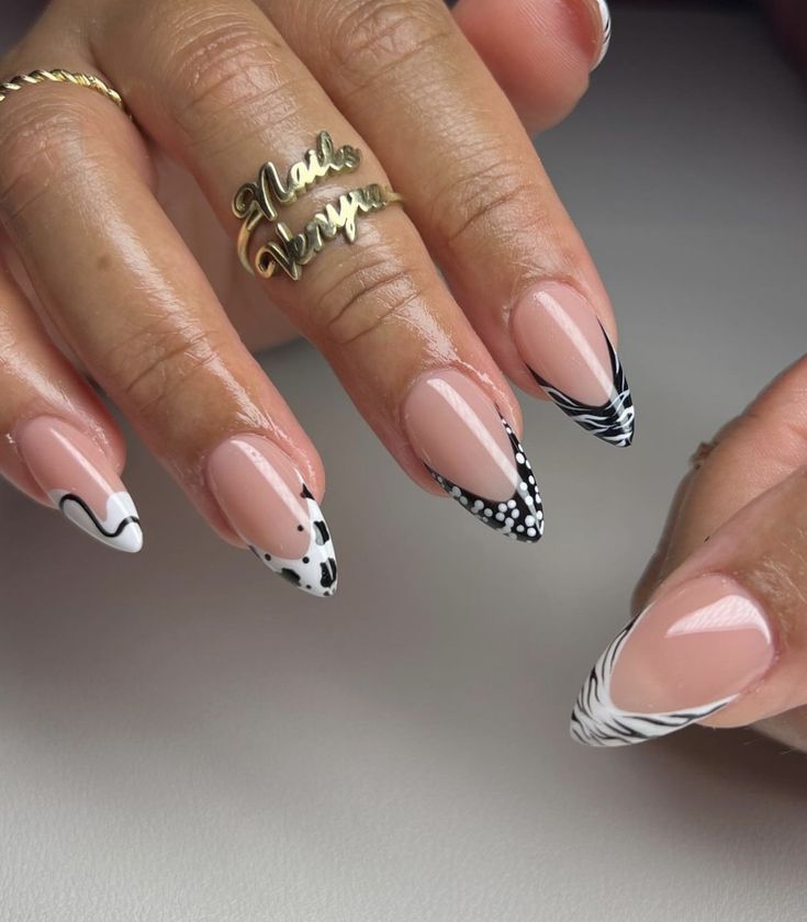 a woman's hands with pink and black nail polishes on their nails, holding a gold ring