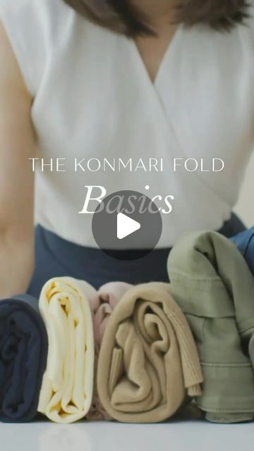 a woman is holding several folded clothes on her lap and the words, the kommari fold basics