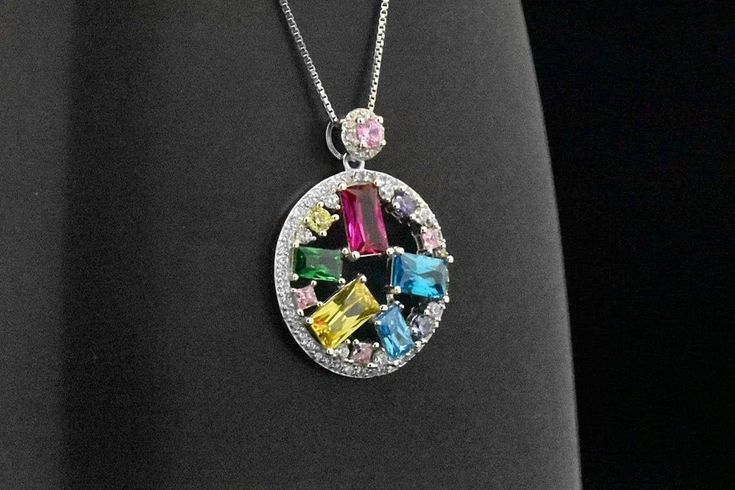 Here we have a beautiful and uniquely designed Classic Art Deco Style circle multi-gemstone pendant. The pendant features the following simulated gemstones: red ruby, blue topaz, green emerald, yellow citrine, pink sapphire and simulated round-cut diamond stones. The total carat weight is about 3.25 cts. The pendant will come with a box chain. Please choose the length of chain (16-in or 18-in). This pendant is also finished in Platinum overlay for the shine & luster of a platinum made jewelr Tennis Jewelry, Topaz Yellow, Silver Coin Necklace, Ruby Pendant, Emerald Pendant, Celestial Jewelry, Yellow Citrine, Star Jewelry, Sterling Silver Necklace Pendants