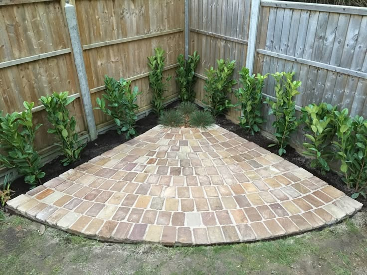 a brick patio in the middle of a yard