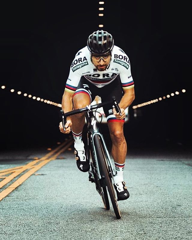 a man riding on the back of a bike down a road