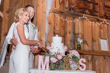 a bride and groom cutting their wedding cake at the reception table with mr and mrs letters on it