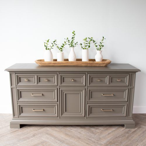 three vases on top of a gray dresser