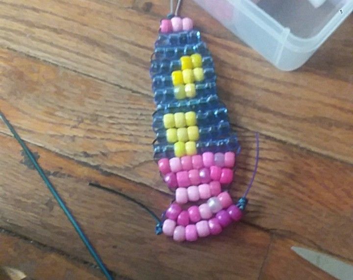 a beaded object sitting on top of a wooden table