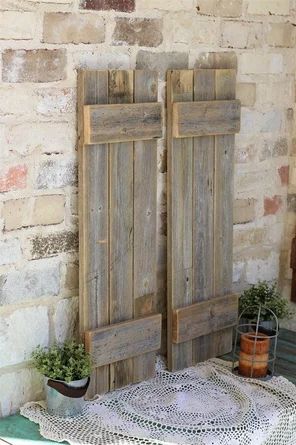 two wooden doors sitting next to each other on top of a white doily covered table