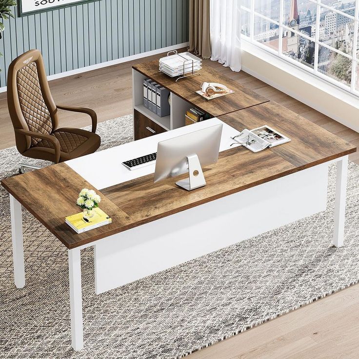 an office desk with a computer on it in front of a window and a chair