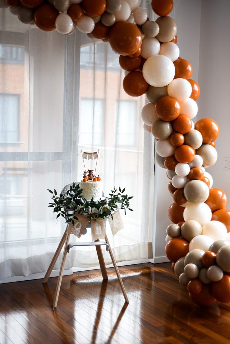 an arch made out of balloons in front of a window