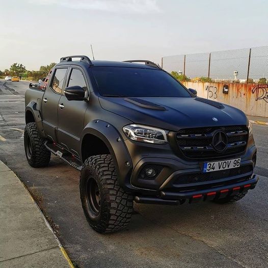 a black mercedes truck parked on the side of the road