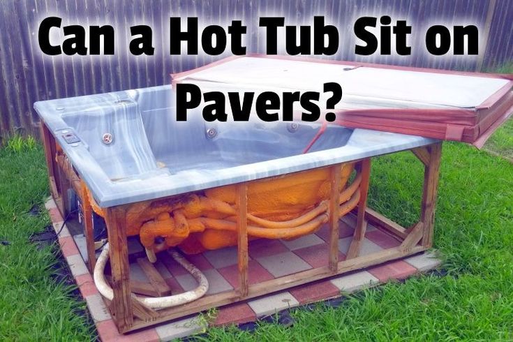 a hot tub sitting on top of a tiled floor next to a green grass covered yard