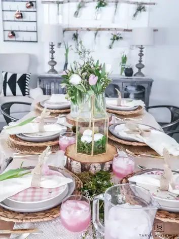 the table is set with plates, cups and vases