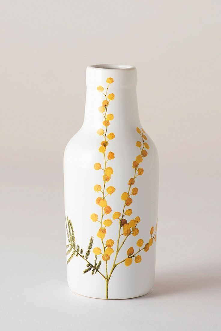 a white vase with yellow flowers painted on it