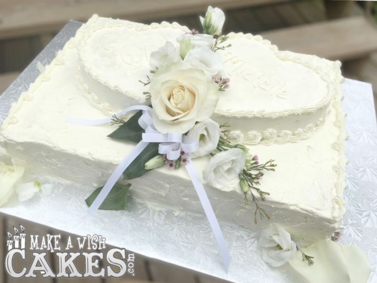 a wedding cake decorated with flowers and ribbons