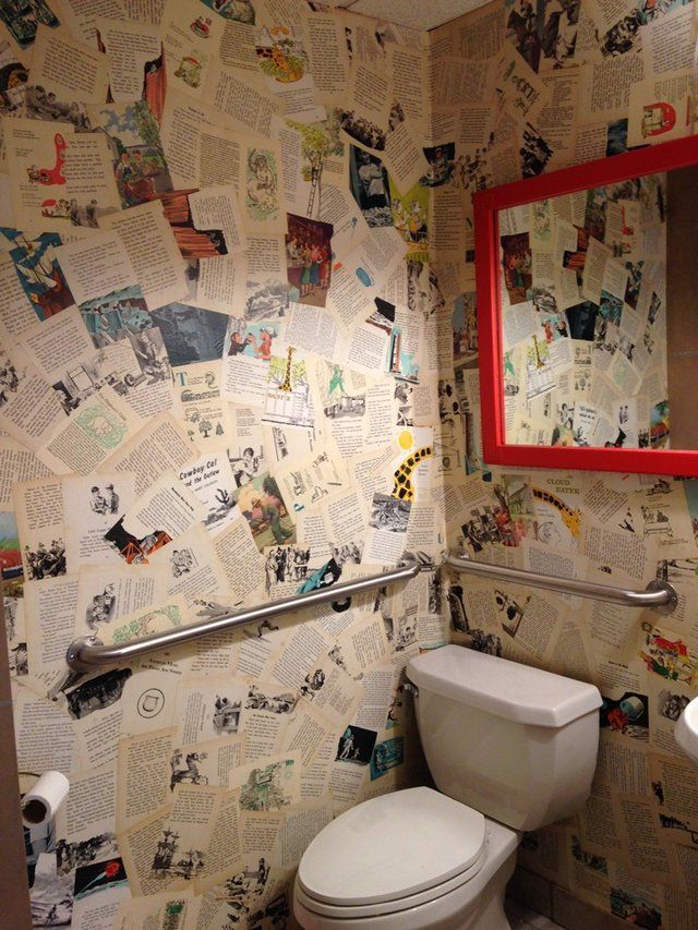 a bathroom with a toilet, mirror and pictures on the wall