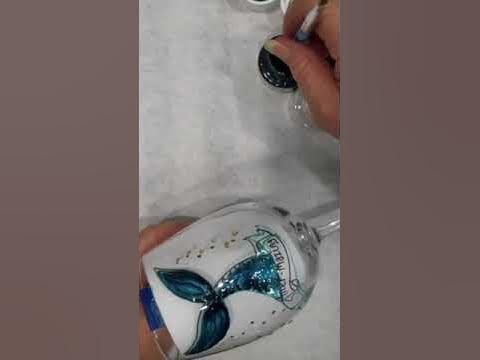 someone is painting their shoes with white and blue glitters