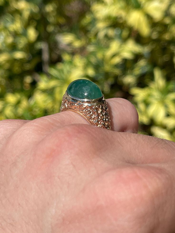 A one of a kind men's natural emerald cabochon ring. This large cabochon gives full finger coverage with its full 16.41-carats. The stone has a beautiful medium dark green color, with very good luster to be admired from any angle. The band has a nugget-style finish, giving the ring more of a classic look. This beautiful oval cabochon is carefully bezel set into a 14K yellow gold setting. Setting Style: Solitaire Setting Material: 14K Yellow Gold Gold Weight: 12.4 Grams Main Stone: Emerald Caboch Emerald Cabochon, Solitaire Setting, Colombian Emeralds, Cabochon Ring, Yellow Gold Setting, Emerald Jewelry, Emerald Gemstone, Pinky Ring, Natural Emerald