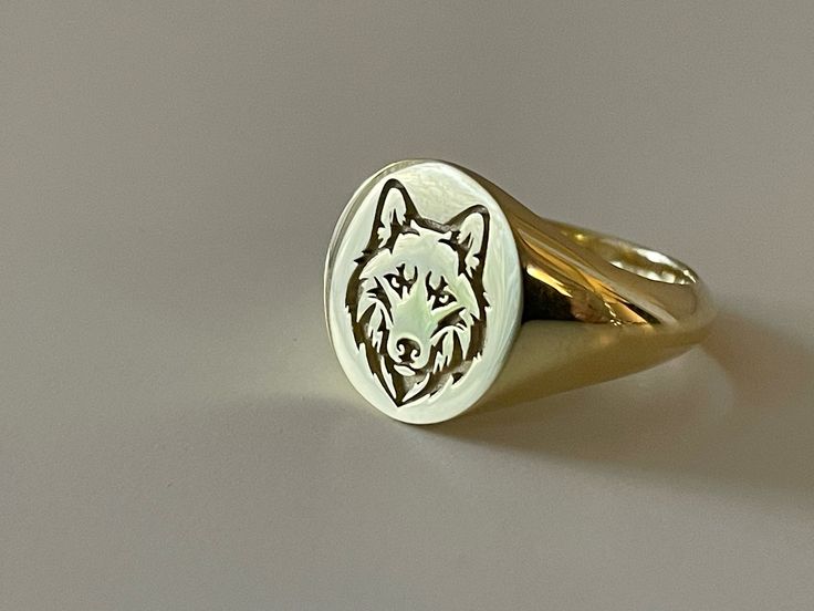 a gold ring with a wolf head engraved on it