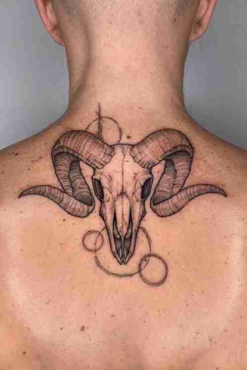 a man with a goat skull tattoo on his back